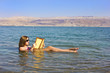 young girl reads a book floating in the Dead Sea in Israel young girl reads a book floating in the Dead Sea in Israel