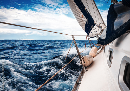  The white sails of yachts on the background of sea and sky in the clouds