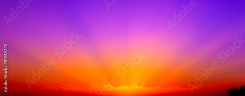 Bellissimo tramonto rosso, arancio, e viola con raggi di sole.