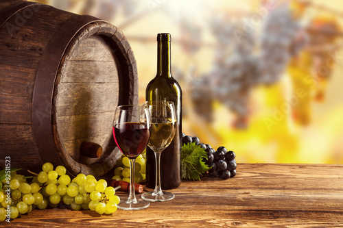 Red and white wine bottle and glass on wodden keg