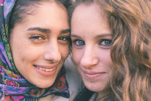 Portrait with two girls from different ethnicity. Muslims and christians people perfectly integrated
