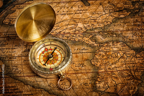 Fototapeta Old vintage golden compass on ancient map