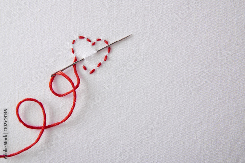 Embroidered red heart on a white cloth top view