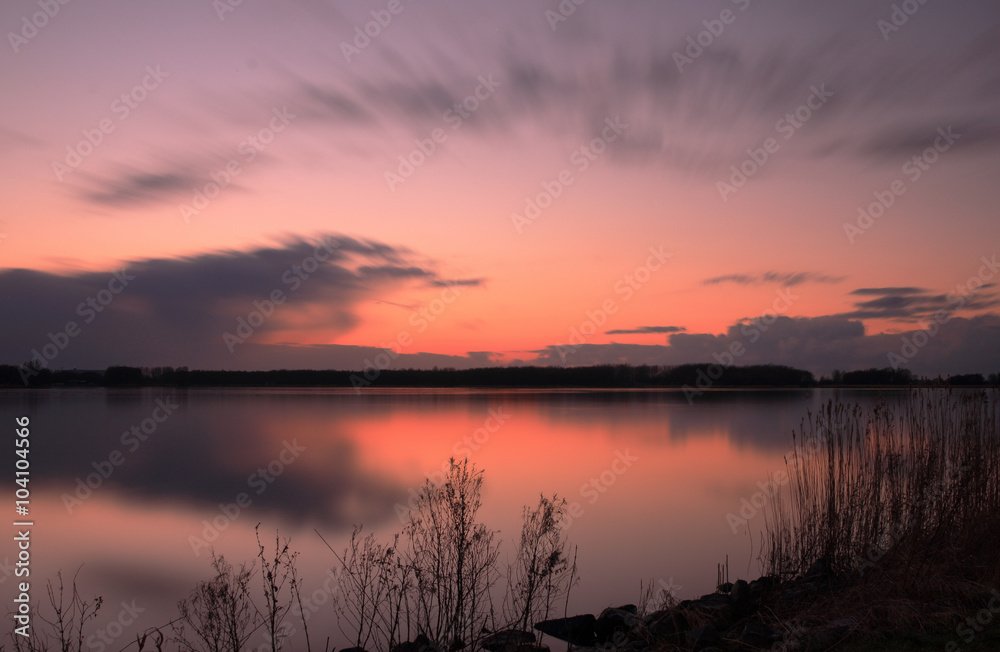 Zonsondergang in het Twiske reacreatiegebied met spiegelend meer