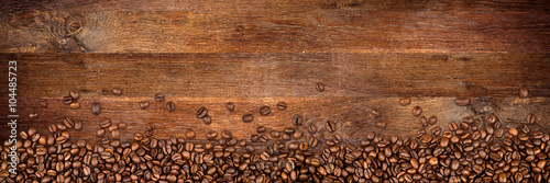 Fototapeta coffee background with beans on rustic old oak wood