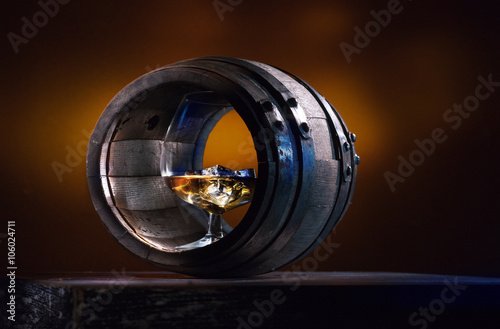 Brandy with ice in a vat of grapes on an orange background