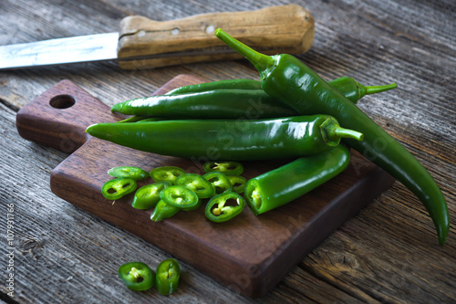 Fresh green chilli on old wooden background