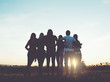 Group of people hugging outdoors; sunset Group of people hugging outdoors; sunset