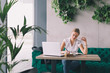 She has a busy coffee break.Woman drinking cafe and working on laptop in cafe bar She has a busy coffee break.Woman drinking cafe and working on laptop in cafe bar