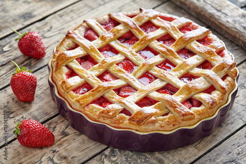 Fotoobraz na płótnie Piec truskawkowego kulebiaka torta słodki ciasto na nieociosanym drewnianym stołowym tle