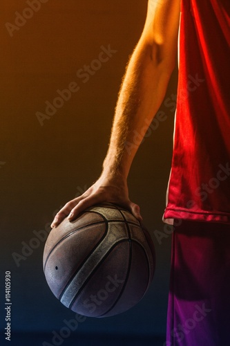 Close up on basketball held by basketball player
