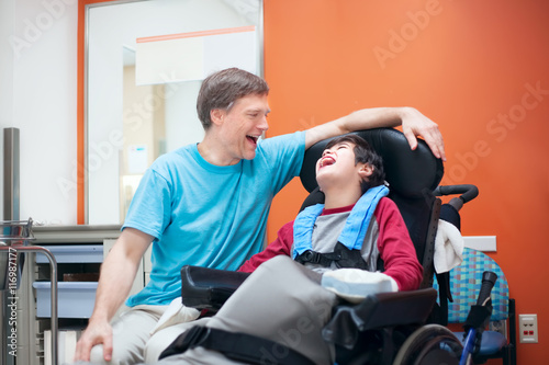 Фото: Disabled little boy in wheelchair talking with father in hospita Disabled little boy in wheelchair talking with father in hospita