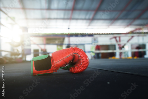Zdjęcie XXL Para jaskrawoczerwonych bokserskich rękawic Muay Thai wisi na ringu w obozie slumsów