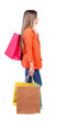 side view of going woman with shopping bags . beautiful girl in motion. backside view of person. Rear view people collection. Isolated over white background. girl in red coat is throwing his bag side view of going woman with shopping bags . beautiful girl in motion. backside view of person. Rear view people collection. Isolated over white background. girl in red coat is throwing his bag