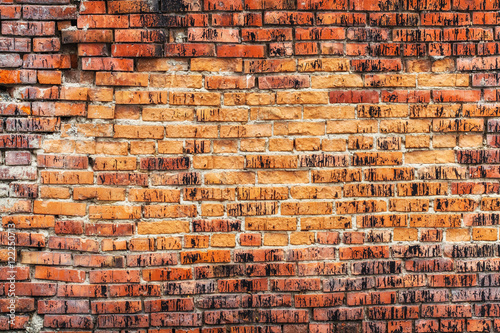 Weathered stained old orange brick wall, texture grunge background