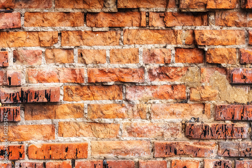 Weathered stained old orange brick wall, texture grunge background