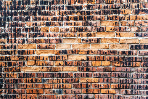 Weathered stained old orange brick wall, texture grunge background