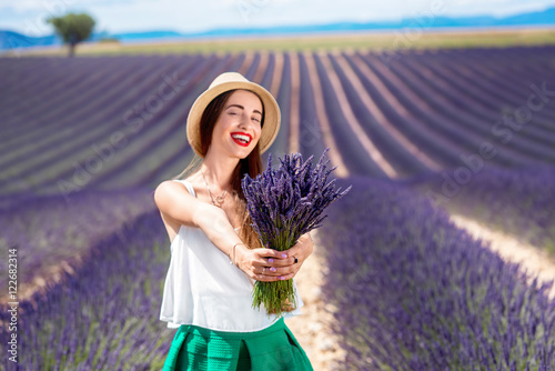 Plakat Młoda kobieta z lawendową bukiet pozycją na lawendowym polu w Provence w Francja