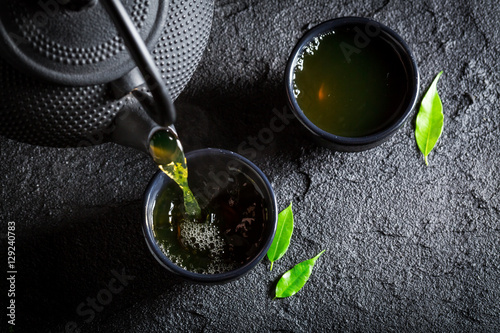 Zdjęcie XXL Wyśmienicie zielona herbata z teapot i filiżanką na czerni kołysa