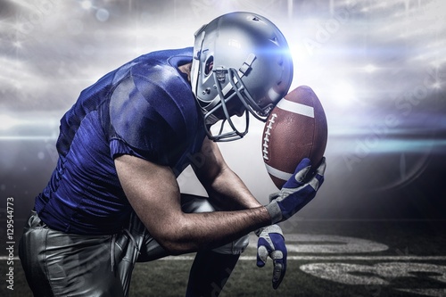Fototapeta Composite image of upset american football player with ball