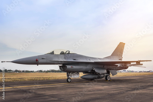Fotoobraz na płótnie F16 sokół myśliwca samolot wojskowy zaparkowany na pasie startowym na zachód słońca
