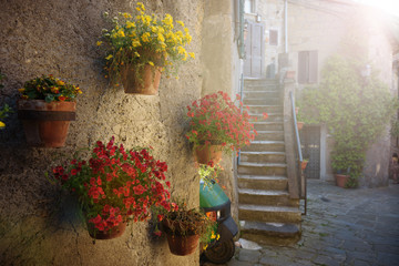 Spring streets of the old Tuscan town. Colorful flowers bloom an