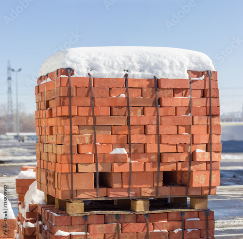 Pallets of the red bricks on a warehouse