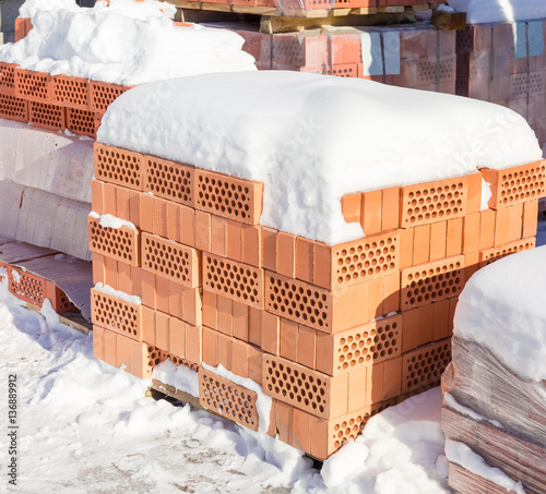 Pallet of the perforated red bricks on an outdoor warehouse