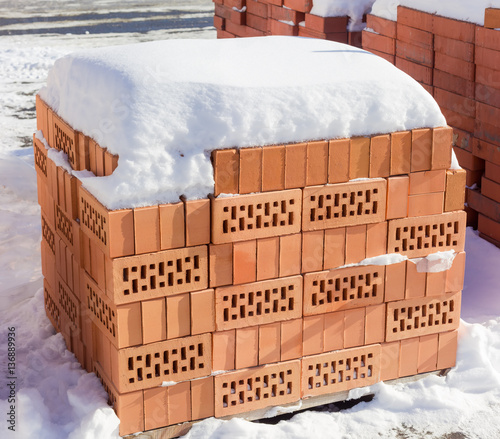 Pallets of the perforated red bricks on an outdoor warehouse