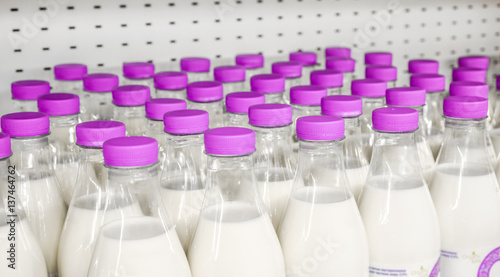 Zdjęcie XXL butelki z mlekiem jako produkt mleczny do przygotowania śniadania czekają na butelkę na półce sklepowej