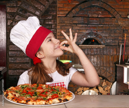 Fotoobraz na płótnie szczęśliwa mała dziewczynka gotuje z pizzą i ok ręką podpisuje wewnątrz pizzeria