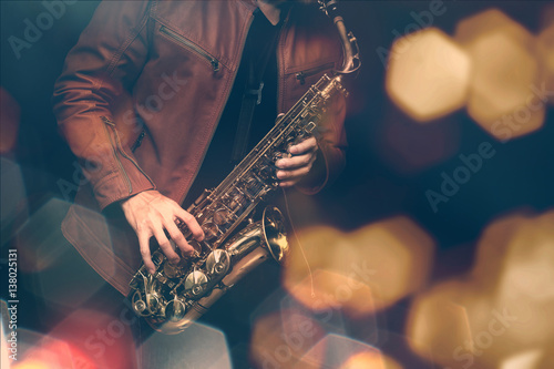 Fotoobraz na płótnie Jazzowy saksofonista w występie na scenie. dodano filtr koloru i sześciokątny bokeh.