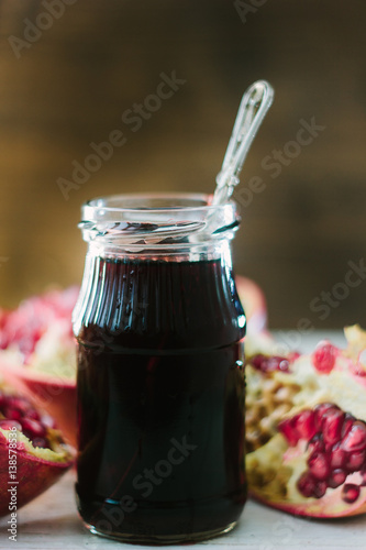 Organic pomegranate sauce on glass bottle with spoon
