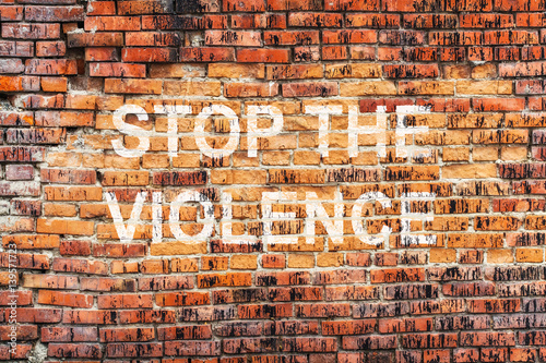 Text STOP VIOLENCE on stained old orange brick wall texture background