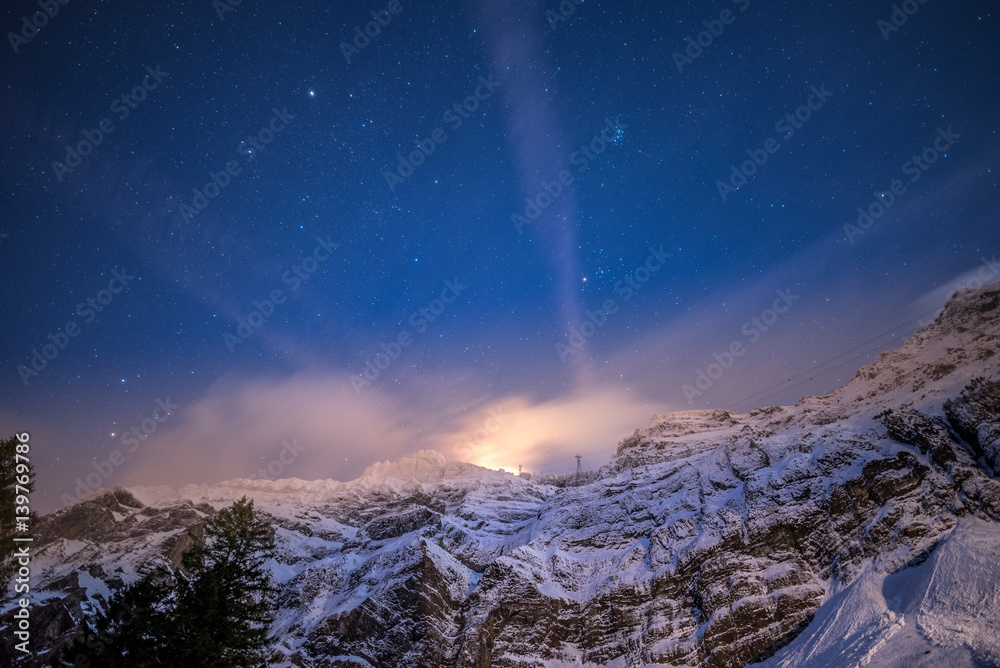 view up to a massive mountain in a clear winter night with shiny stars