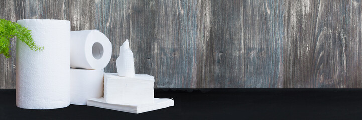 Paper tissue, paper towel and napkins on wooden background. Wide panoramic image. 