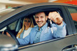 Young couple holding the keys of a new car Young couple holding the keys of a new car