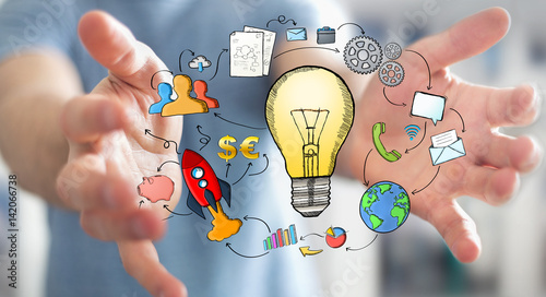 Businessman holding hand drawn lightbulb and multimedia icons