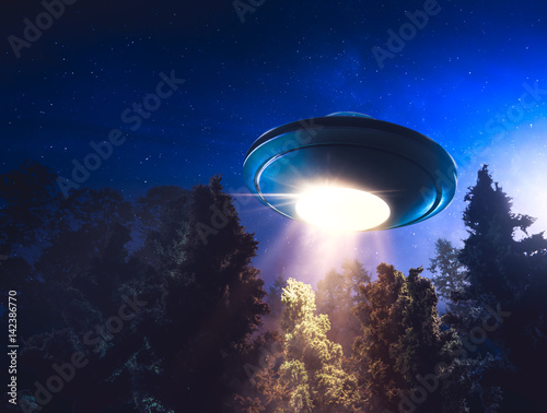 Fotoobraz na płótnie Wysoki kontrast obrazu UFO lecący nad lasem z wiązki światła w nocy