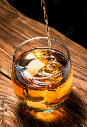 whiskey with ice on a wooden table
