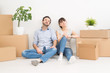 A young couple sitting on the floor and looking up. Dream and enjoy a new home. A young couple sitting on the floor and looking up. Dream and enjoy a new home.