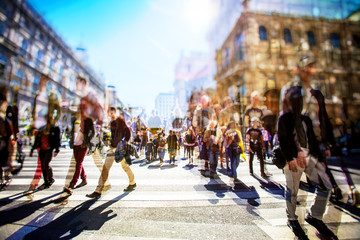 Crowd of anonymous people walking on busy city street