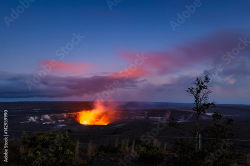 Plakat Ognista poświata jeziora lawy aktywnego krateru Kilauea w Halemaumau oświetla różowe chmury o niebieskiej godzinie. Widok z Muzeum Jaggar, Park Narodowy wulkanów, Big Island, Hawaje.