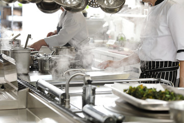 Chef in hotel or restaurant kitchen cooking
