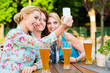 Freundinnen machen ein Selfie im Biergarten Freundinnen machen ein Selfie im Biergarten