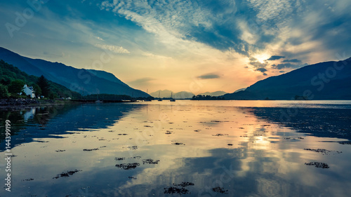 Colorful sunset over the boats on lake in Scotland