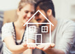 Young couple holding their new, dream home in hands Young couple holding their new, dream home in hands