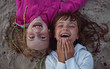 young friends laughing while lying on the beach young friends laughing while lying on the beach