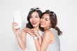 Portrait of two beautiful asian fashionable women taking selfie Portrait of two beautiful asian fashionable women taking selfie