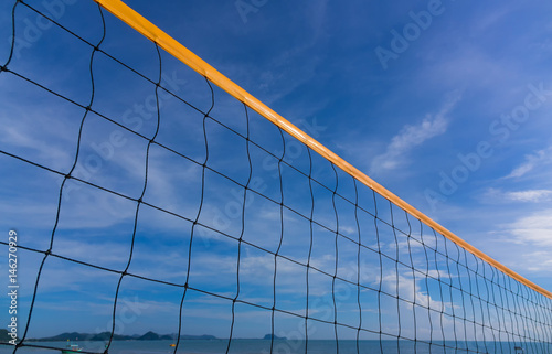 Plakat Zbliżenie plażowej siatkówki sieć na plaży z pogodnym i pogodnym niebem